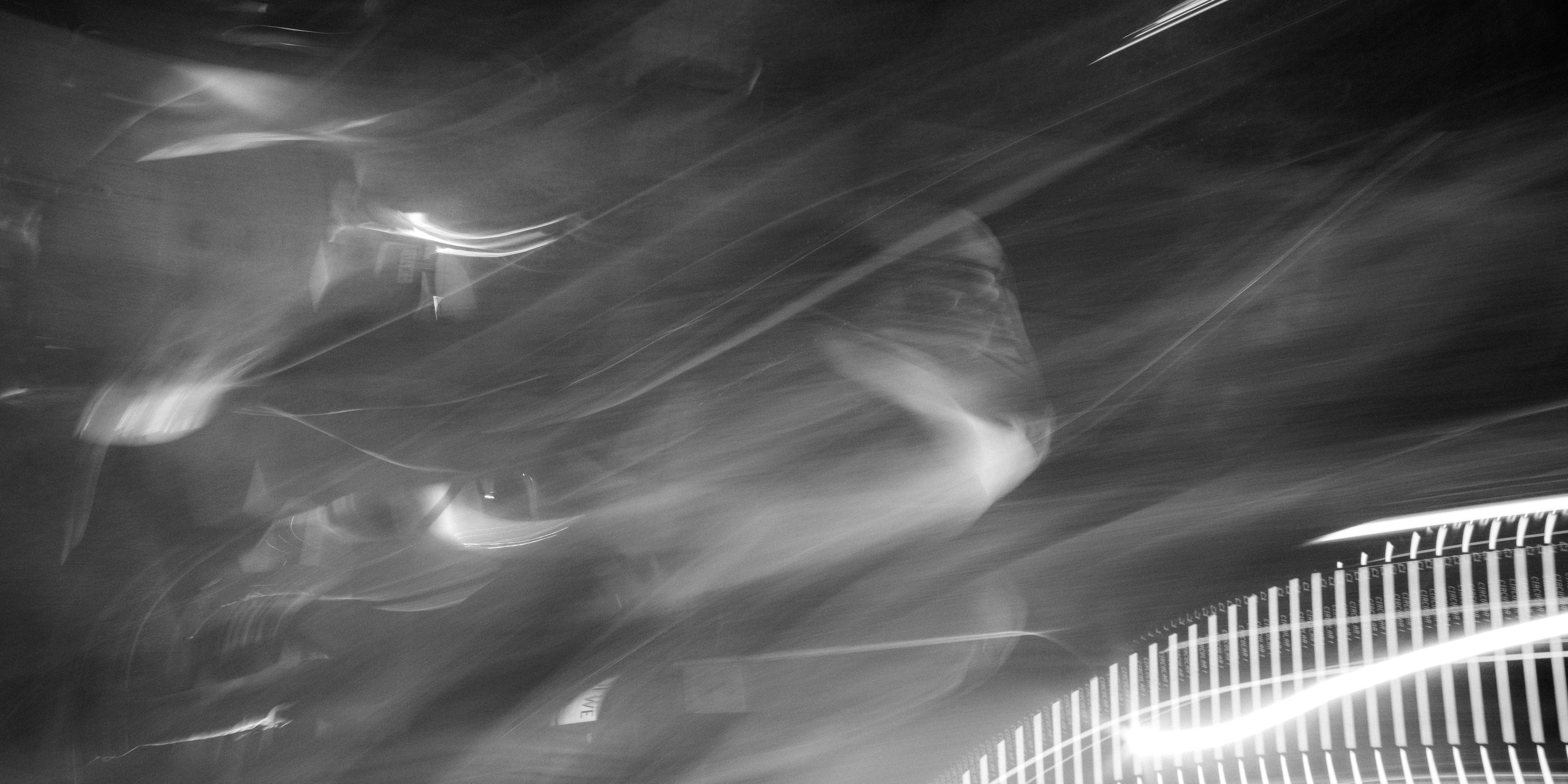 Long-exposure light streaks across a dark data-center scene